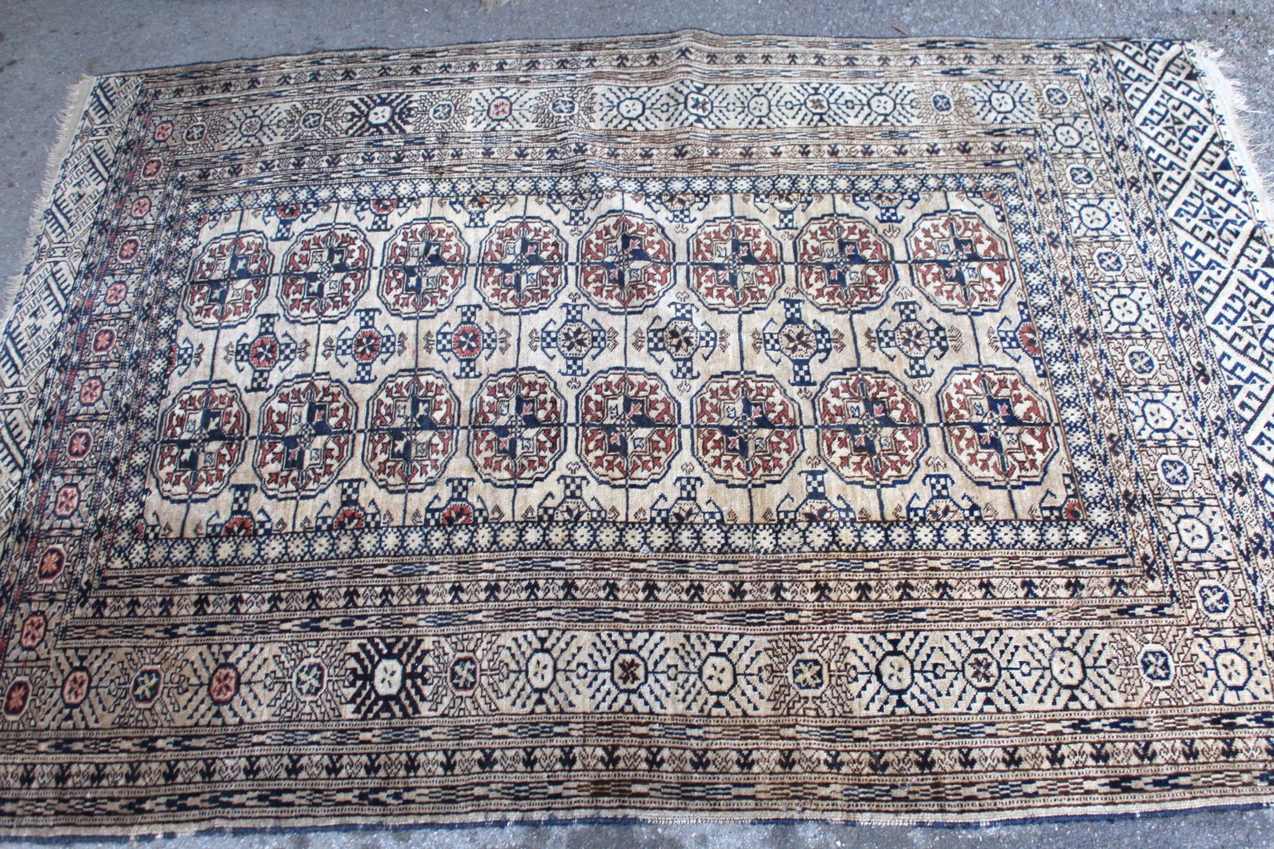 Turkoman rug, the three rows of gols and multiple borders on a washed beige, red and blue ground,