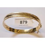 9cy Yellow gold bangle with engraved decoration and safety chain, measures 19cm inside, 13.5g