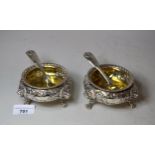 Pair of George IV silver circular open salts, the repousse relief floral decorated bodies with