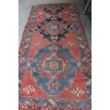 Kurdish rug with a medallion design on a wine ground with borders