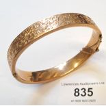 9ct Gold and floral engraved bangle, internal measurements 60mm x 50mm approximately, 13.5g