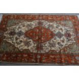 Indo Persian rug with a medallion and hunting design in shades of iron red and cream, 183cms x