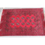 Small Afghan rug with two rows of five gols on a wine red ground with borders, 112cms x 76cms