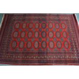Pakistan rug of Turkoman design with three rows of gols on a wine ground with borders, 183 x 126cm
