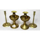 Pair of brass candlesticks with bowl form drip trays, together with a pair of brass slender column