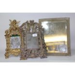 Ornate brass table mirror with back stand, 36cm high, together with a similar painted cast iron