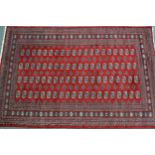 Pakistan rug of Turkoman design with four rows of gols on a red ground with borders, 290 x 190cm