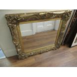 19th Century gilded composition frame housing a later rectangular mirror plate, 107 x 92cm (losses)