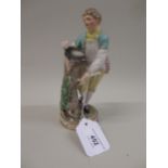 Meissen figure of a boy standing beside a tree stump with a bird's nest in his hat, 18cm high (