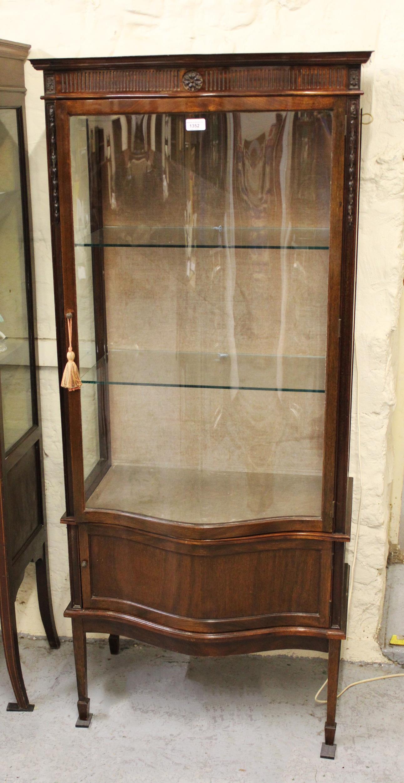 Mid 20th Century mahogany display cabinet with a serpentine glazed door above a serpentine panel