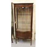 Mid 20th Century mahogany display cabinet with a serpentine glazed door above a serpentine panel