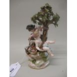 Meissen figural group with Cupid sharpening an arrow seated beneath a tree with another Cupid, 20.