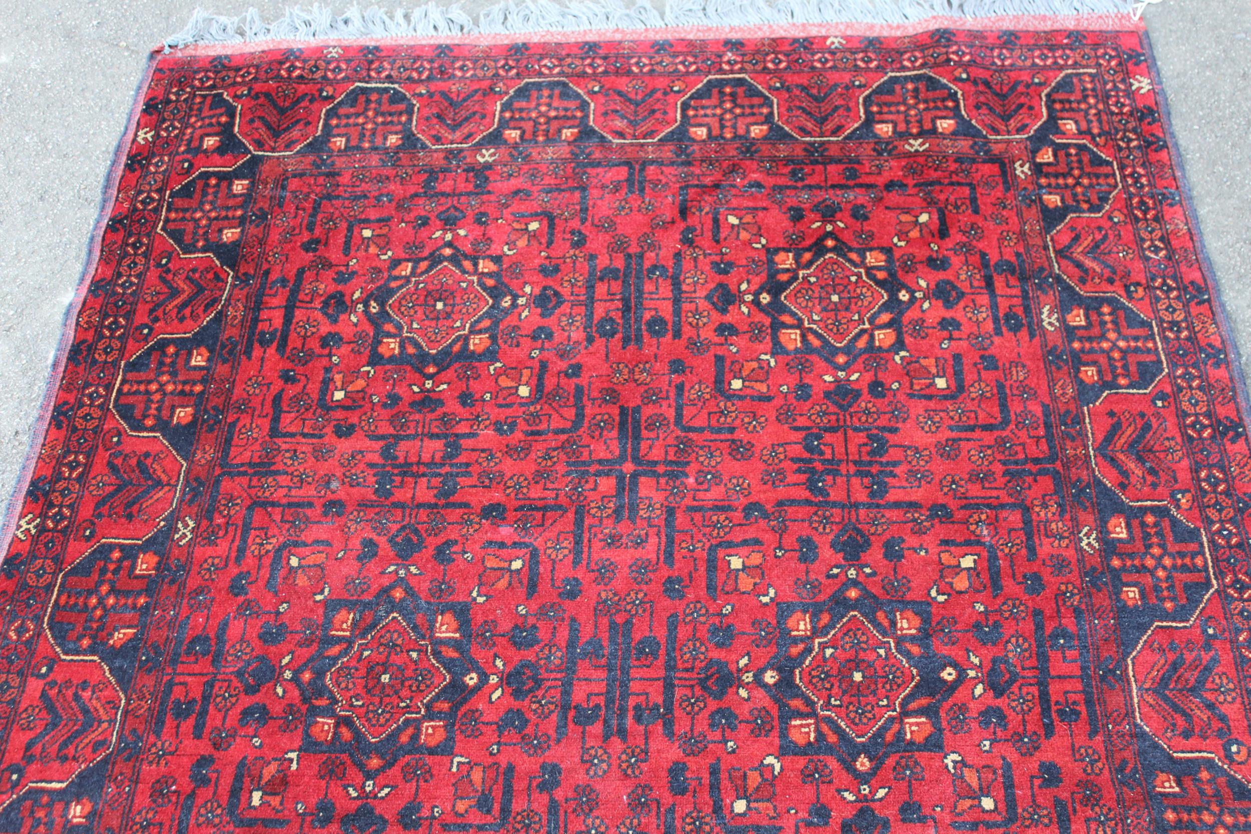 Modern Afghan Belouch rug of six panel design with a dark red ground and borders, 190 x 128cm - Image 2 of 4