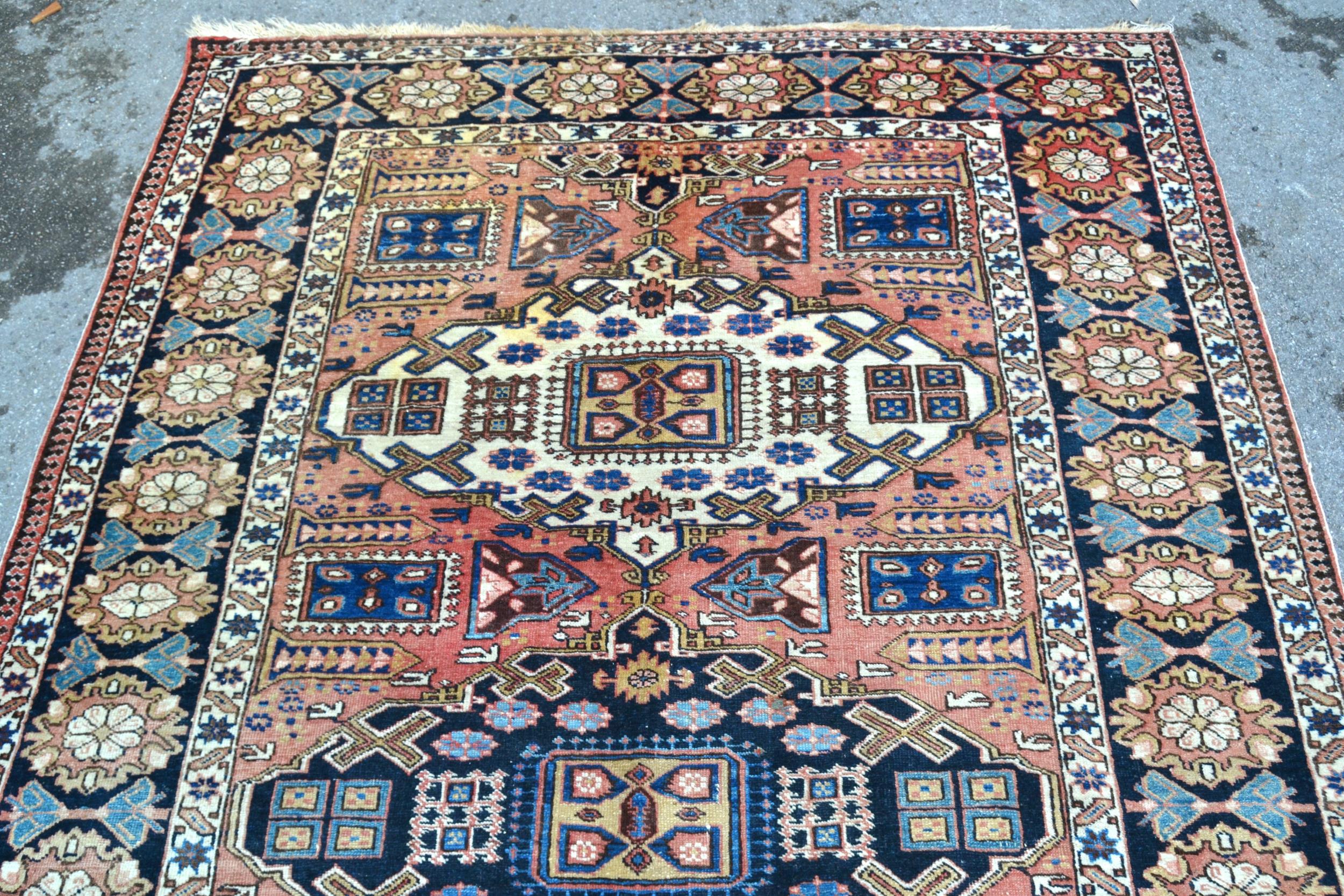 Kazak rug with a triple medallion design on a rose ground with rosette border, 218 x 146cm Some - Image 2 of 3