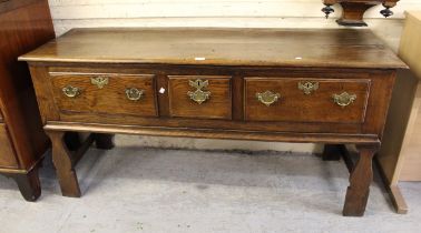 Small 18th Century oak dresser base, the plank top above three drawers with brass handles and