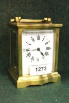 Small brass cased carriage clock with enamel dial and Roman numerals, in a bow fronted case, 10cm