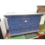 Modern blue painted panelled trunk with hinged cover, brass carrying handles and turned bun