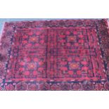 Modern Afghan Belouch rug with a four panel design on a dark red ground with borders, 142 x 104cm