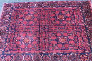 Modern Afghan Belouch rug with a four panel design on a dark red ground with borders, 142 x 104cm