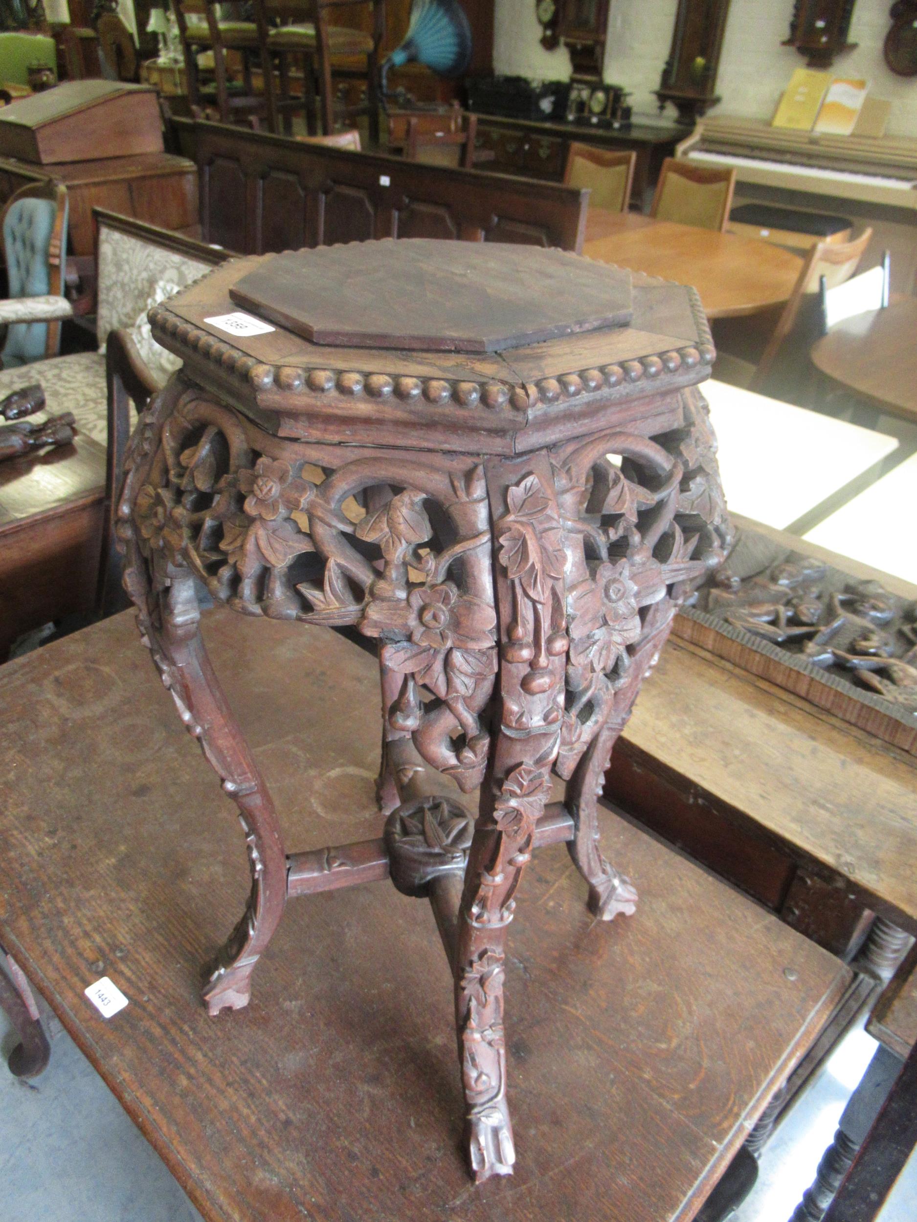Chinese carved hardwood vase stand, the octagonal top above a pierced frieze and shaped supports,