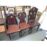 Two Victorian mahogany hall chairs, together with a late Victorian mahogany single hall chair