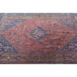 Qashqai rug with a medallion and all-over stylised floral design on a red ground with borders, 243 x