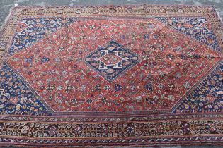 Qashqai rug with a medallion and all-over stylised floral design on a red ground with borders, 243 x