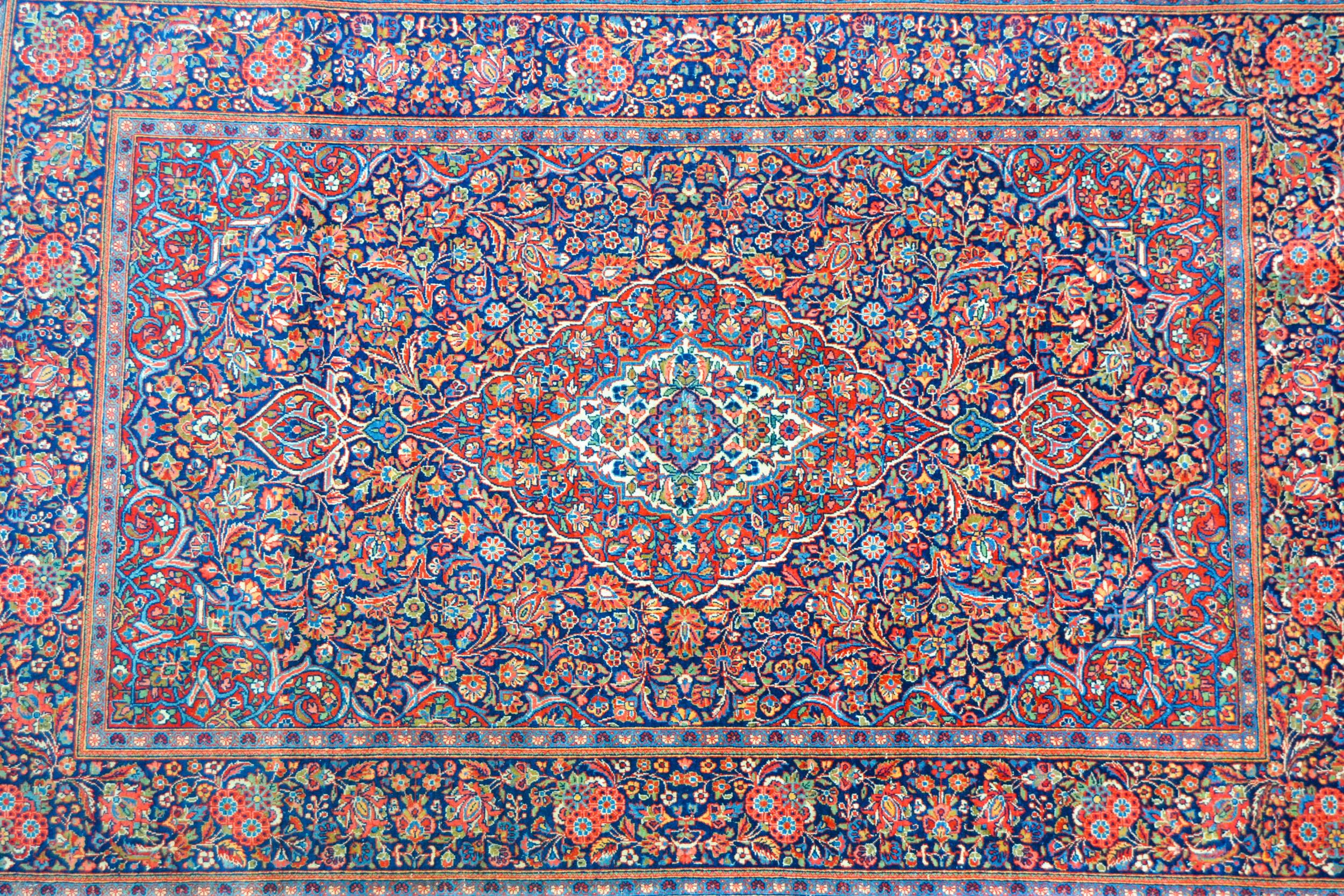 Kashan rug with a busy lobed medallion and floral design on a midnight blue ground with borders, 201