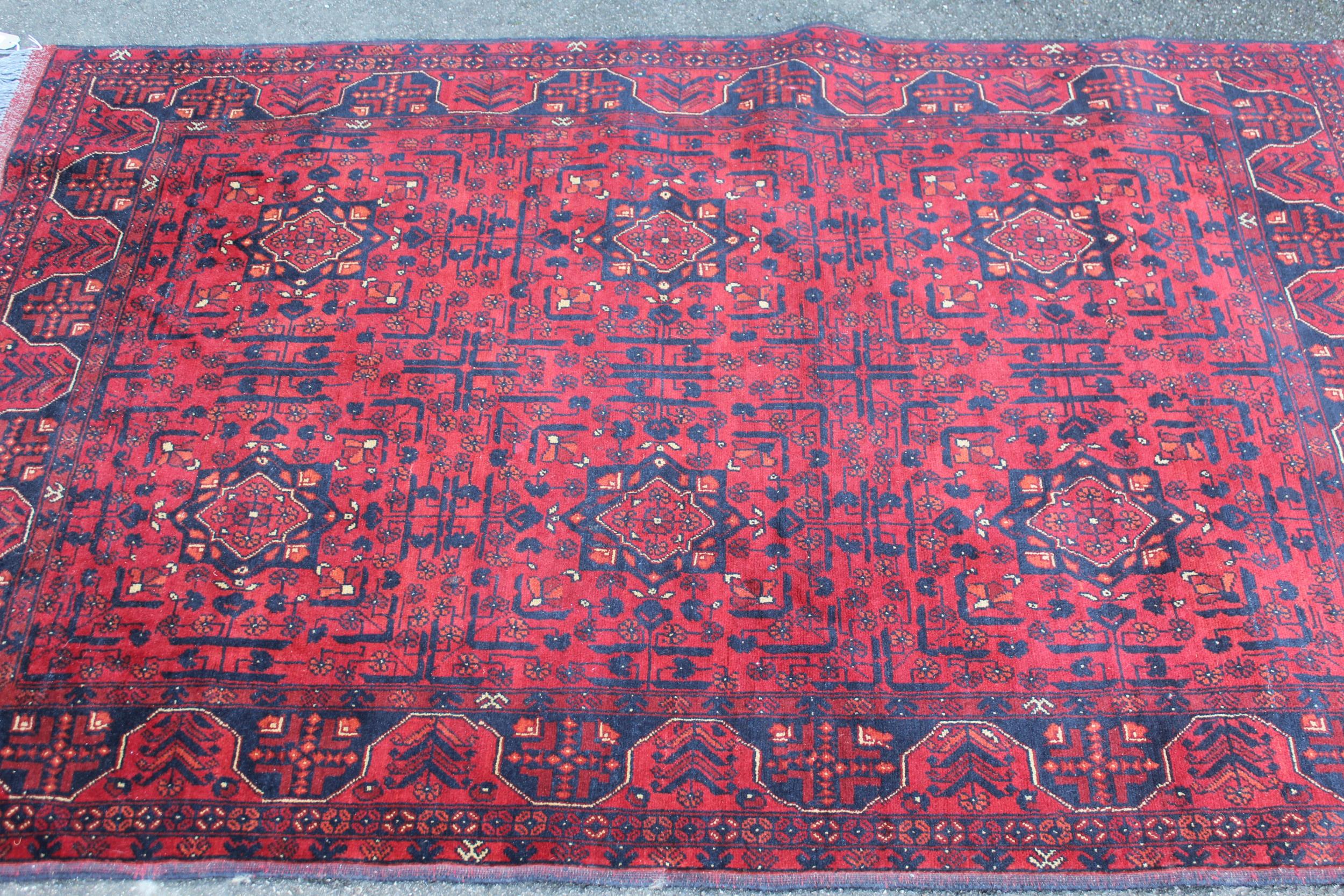 Modern Afghan Belouch rug of six panel design with a dark red ground and borders, 190 x 128cm