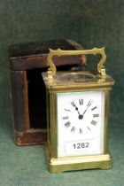 Small brass cased carriage clock having original outer leather covered case