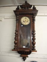 Late 19th Century walnut Vienna type wall clock with a mask head surmount above a painted dial