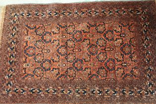 Indo / Persian rug with an all-over stylised flowerhead design on madder ground with borders, 180