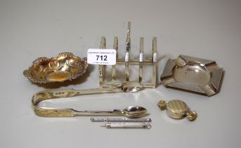Silver toast rack, trinket dish, ashtray, swizzle stick, toothpick, pair of sugar tongs and a