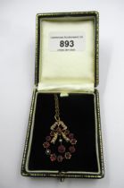 Edwardian gold pendant of bow form set rubies and seed pearls suspended from a gold plated chain