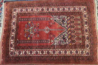 Afghan prayer rug with typical design on a red ground, 156 x 110cm (slight damage)