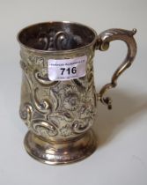 George III silver baluster form mug with chased and embossed relief decoration and scroll handle,