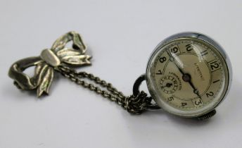Silver plated ball watch suspended from a bow
