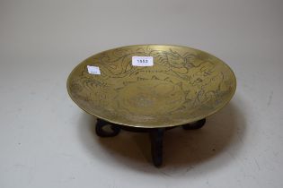 20th Century Chinese circular engraved bronze dish decorated with dragons, 25cm diameter, on a