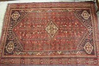 Afshar rug with a medallion and all-over stylised floral design in shades of red and blue, with