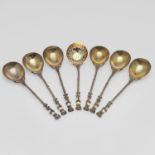 A VICTORIAN CASED SET OF SIX SILVERGILT SPOONS AND MATCHING SUGAR SIFTER.