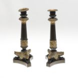 A PAIR OF FRENCH EMPIRE STYLE BRONZE AND GILT CANDLESTICKS.