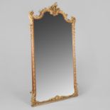 A CARVED OAK AND PARCEL GILT WALL MIRROR.