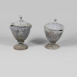 A PAIR OF LEAD GARDEN URNS AND COVERS.