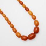 A SINGLE ROW GRADUATED AMBER BEAD NECKLACE.