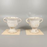 A PAIR OF WHITE PAINTED CAST IRON TWO HANDLED URNS.