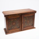 A VICTORIAN DECORATED OAK COIN CABINETS CONTAINING A VARIETY OF COINS.