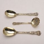 A CASED PAIR OF VICTORIAN SILVERGILT SERVING SPOONS & MATCHING SUGAR SIFTER.