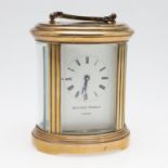 A BRASS OVAL CARRIAGE CLOCK BY MATTHEW NORMAN.