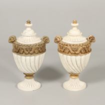 A PAIR OF REGENCY STYLE RESIN URNS AND COVERS.