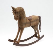 A CARVED WOODEN TOY ROCKING HORSE.